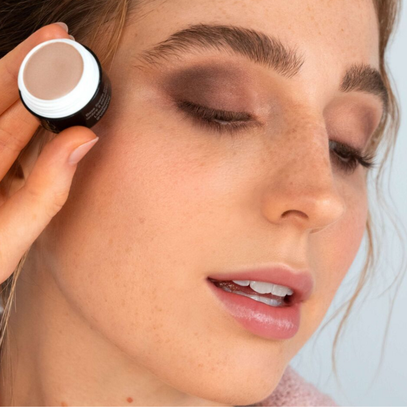 Frau mit rötlichen Haaren hält die ARTDECO Eyeshadow Base and ihre geschminken Augen