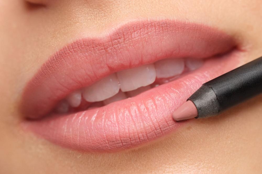 Es werden geschminkte Lippen gezeigt, wobei ein Lipliner zum Auftrag vorgezeigt wird