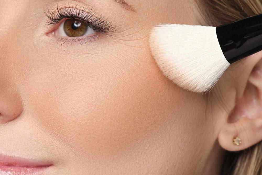Bronzer wird auf das Gesicht aufgetragen