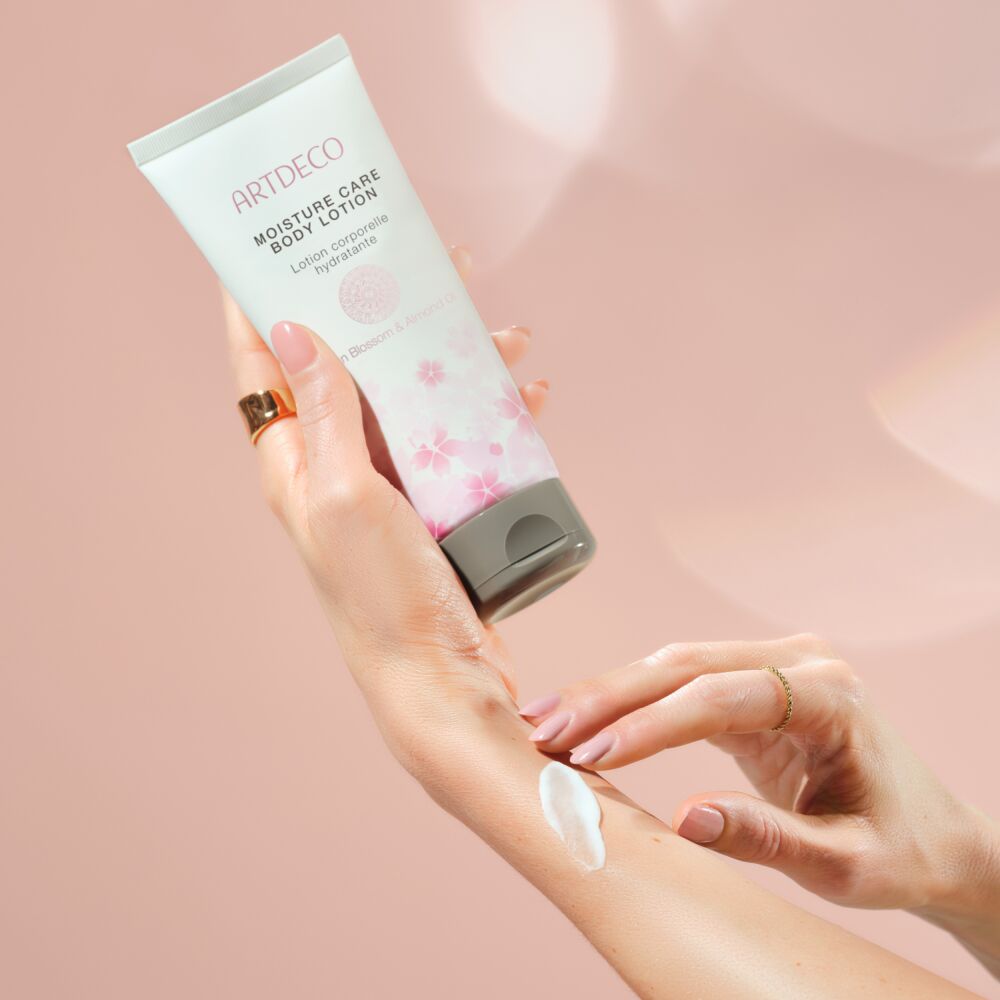 Anwendungsbild des Moisture Care Body Lotion und angenehm zartem Kirschblütenduft