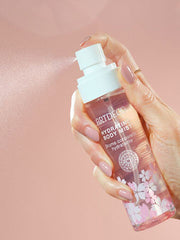 Hydrating Body Mist mit zartem Kirschblütenduft wird versprüht und der feiner Sprühnebel ist deutlich zu erkennen