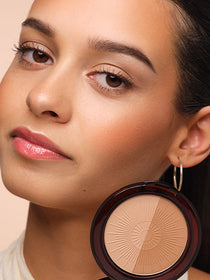 Close-up auf das Gesicht des Models welches das Bronzing Powder Compact an die Wange hält