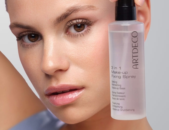 Model hält das ARTDECO 3 in 1 Make-Up Fixing Spray an ihr geschminktes Gesicht.