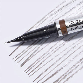 Close Up von der ultradünnen Spitze des 24h Micro Brow Liquid Liner mit Swatch im Hintergrund.