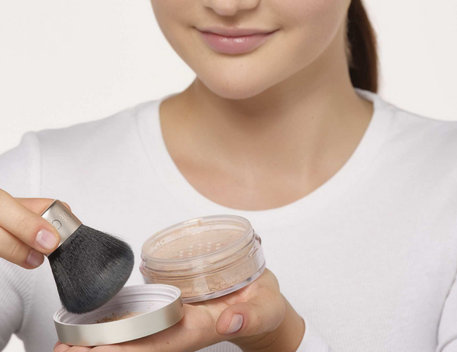 Ein wenig Puder der Mineral Powder Foundation wird in den Deckel gegeben und mit einem Puderpinsel aufgenommen