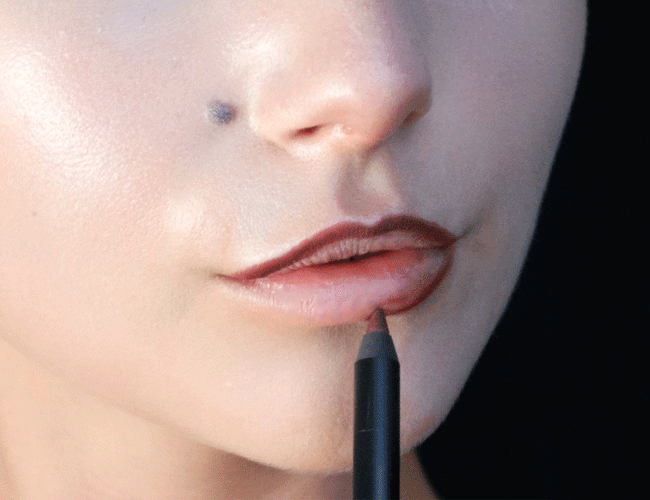 GIF in welchem gezeigt wird, wie die Lippen des Models mit einem roten Lipliner umrandet werden und am Schluss mit einem roten Lippenstift ausgefüllt werden.