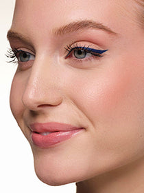 Das Model ist im Profil zu sehen, und der Fokus liegt auf ihrem blauen Eyeliner