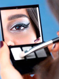 Beauty Box mit drei Lidschatten und geschminktem Cat Eye im Spiegel