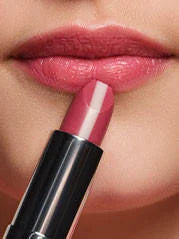 Ein pflegender Lippenstift wird an Lippen in der gleichen Farbe drangehalten