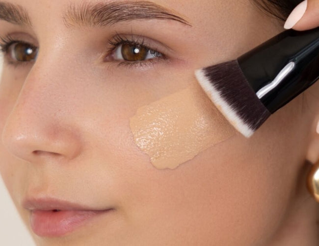 Model trägt eine flüssige Foundation für das Latte Make-Up auf.