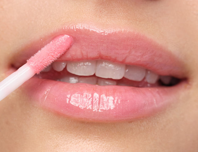 Close-up auf die Lippen des Models, auf welche das Plumping Lip Fluid N°16 gleaming rose auftragen wird