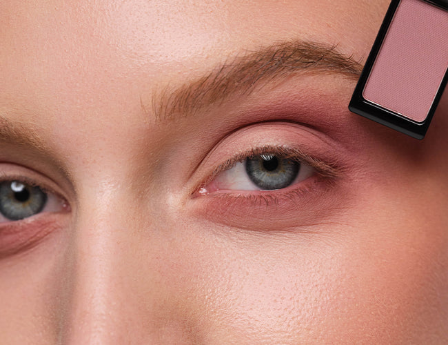 Close-up auf das Auge des Models auf, welches eine beerige Lidschatten-Nuance aufgetragen wurde, um das Augen-Make-up zu intensivieren