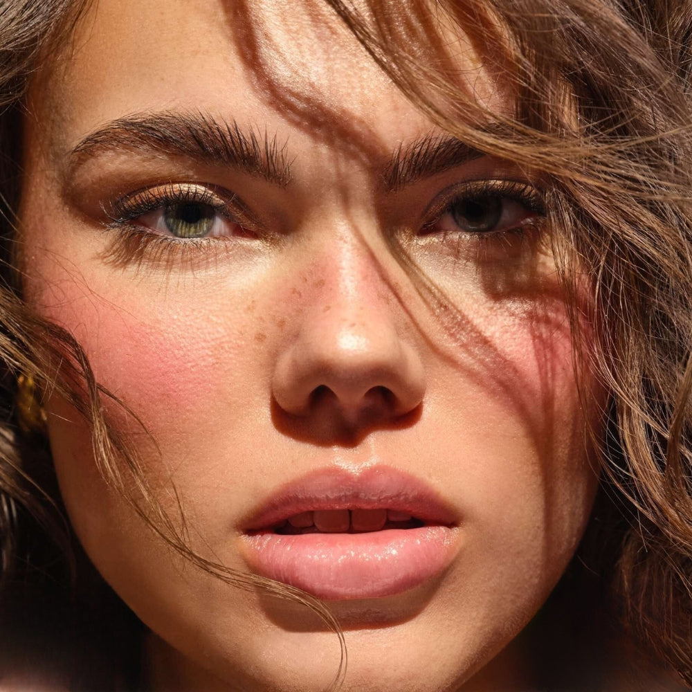Model mit geröteten Wangen und lockigem Haar.
