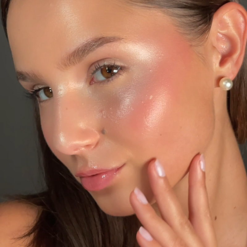 Geschminktes Model mit einem glänzenden Make-up schaut seitlich in die Kamera.