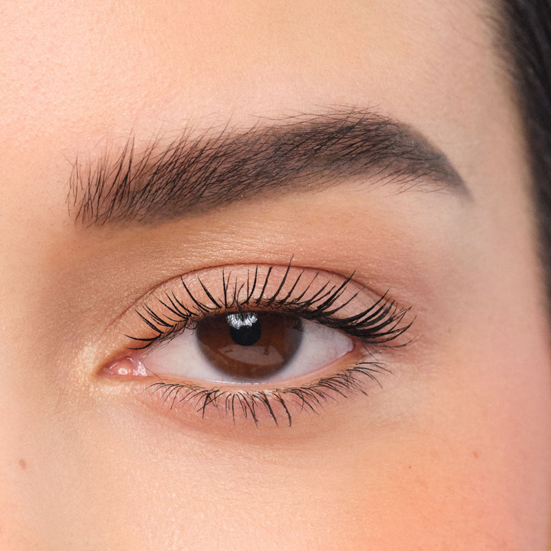 Geschminktes Auge mit buschigen und aufgefüllten Augenbrauen.