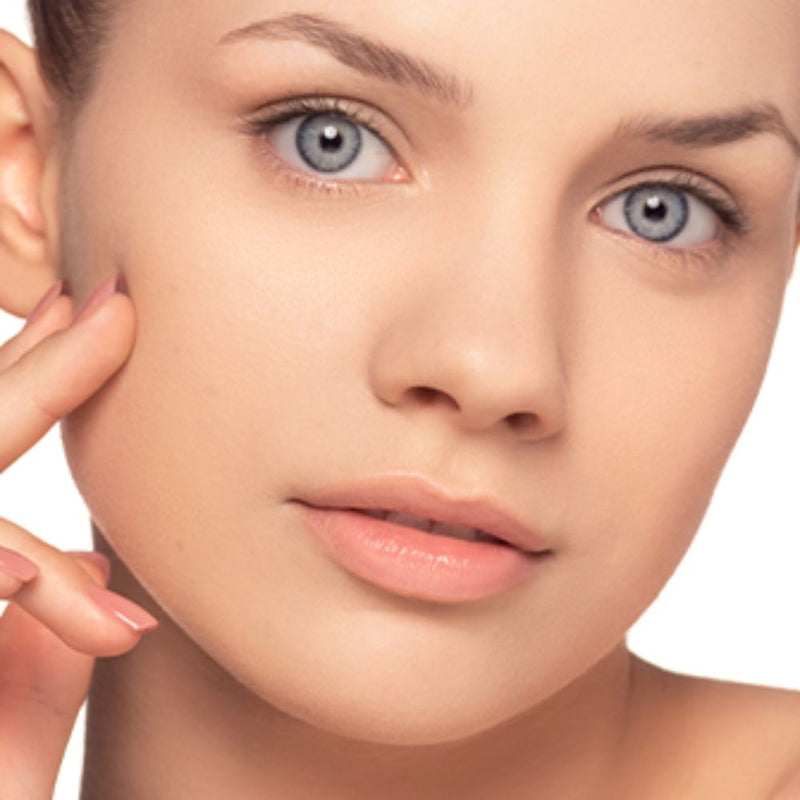 Frau mit ebenmäßigen Teint zeigt wie man unebene Haut abdecken kann