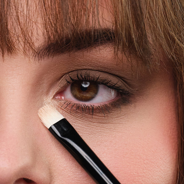 Heller Lidschatten wird am Augeninnenwinkel mit einem Pinsel aufgetragen für den perfekten Smokey Eye-Look