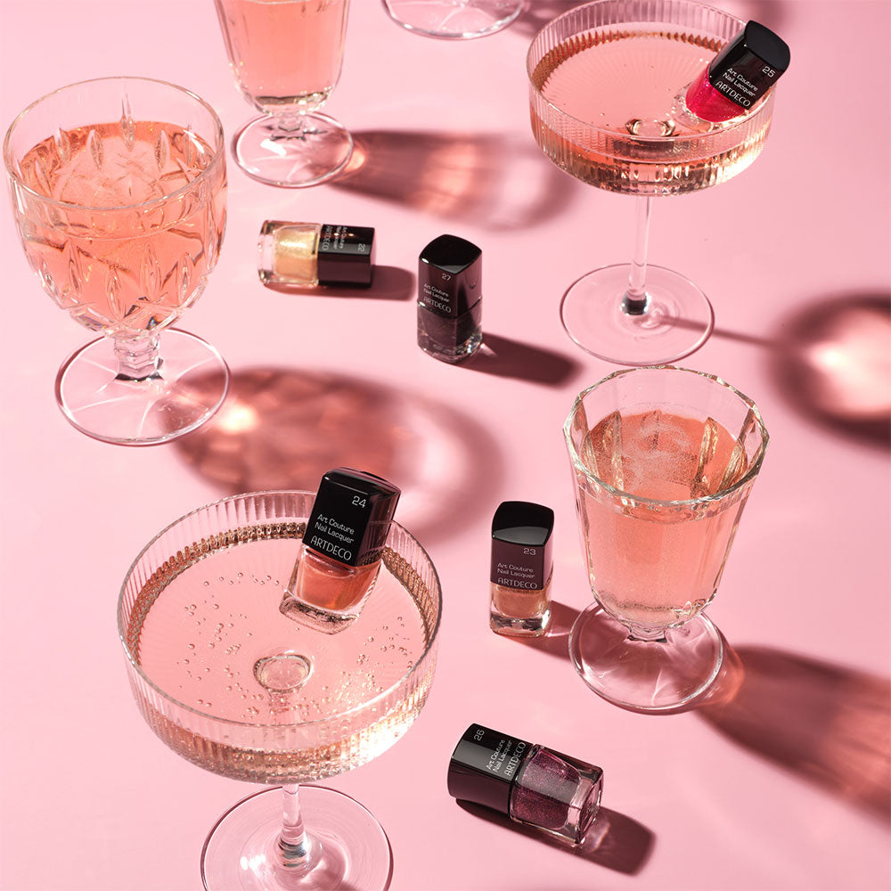 Mood Bild der Art Couture Nail Lacquer Mini-Edition und Sektgläsern auf rosafarbenen Hintergrund