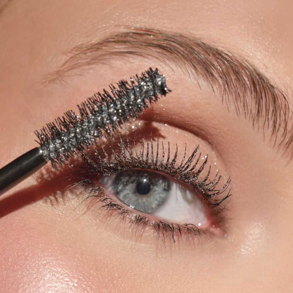 Close-up auf die glitzernden Wimpern des Models, auf welchen die Eyelights Mascara N°3 aufgetragen wurde