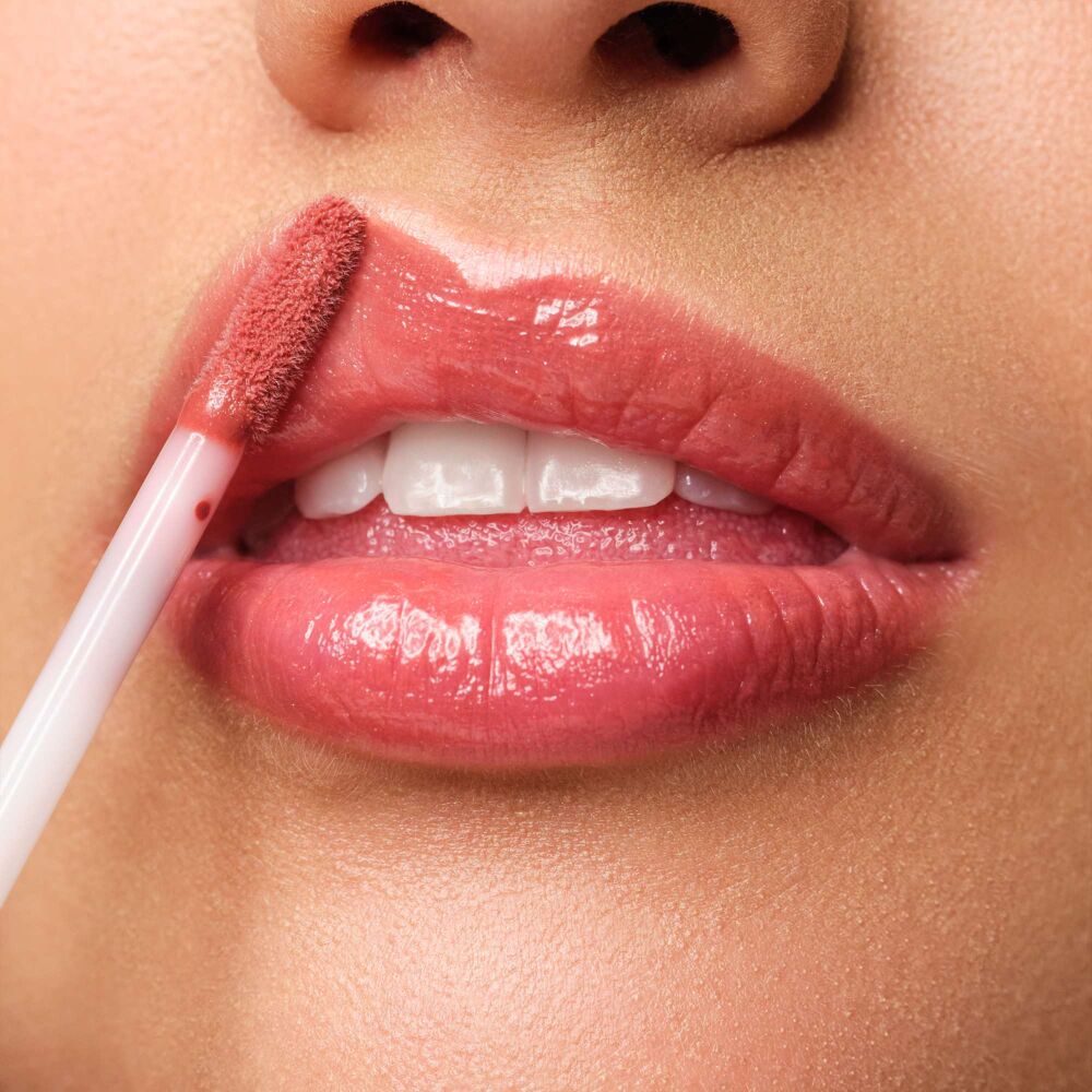 Close-up auf eine Lippe, auf welche das  Plumping Lip Fluid N°28 augetragen wird. Jetzt zusammen mit passenden Lip Liner im Set shoppen.