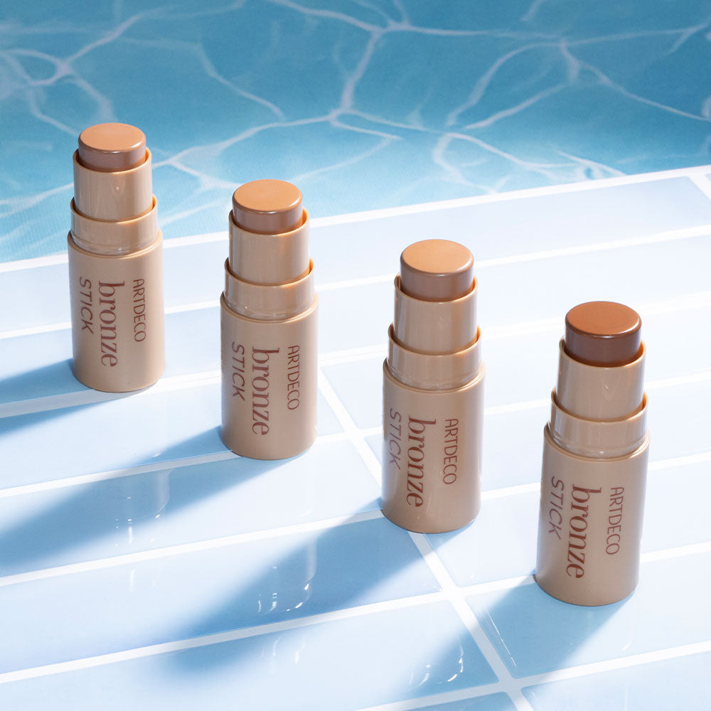 Alle Artdeco Bronze Stick Produkte am Poolrand mit Wellen im Hintergrund. 