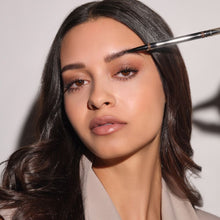 Braunhaariges Model trägt den 24h Micro Brow Liquid Liner auf die Augenbraue aus