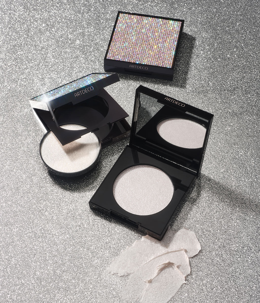 Diamond Beauty Powder wird einmal geschlossen, geöffnet und in der nachfüllbaren Variante auf einem silbernen Hintergrund liegend dargestellt