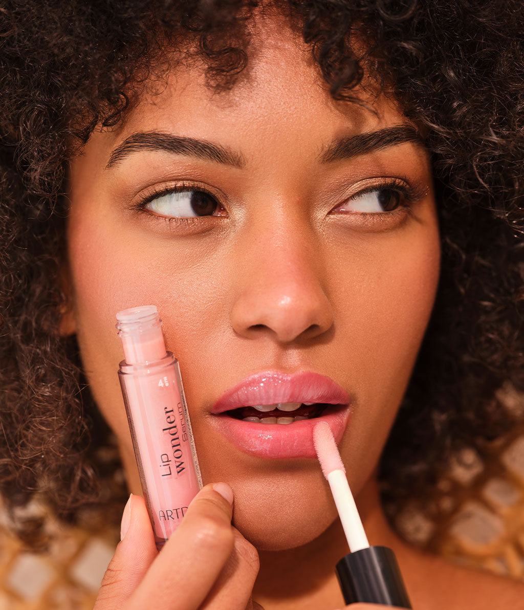 Close-up auf das Model, welches eine der vier Farben des Lip Wonder Serums aufträgt für gepflegte Lippen mit dezenter Farbe.