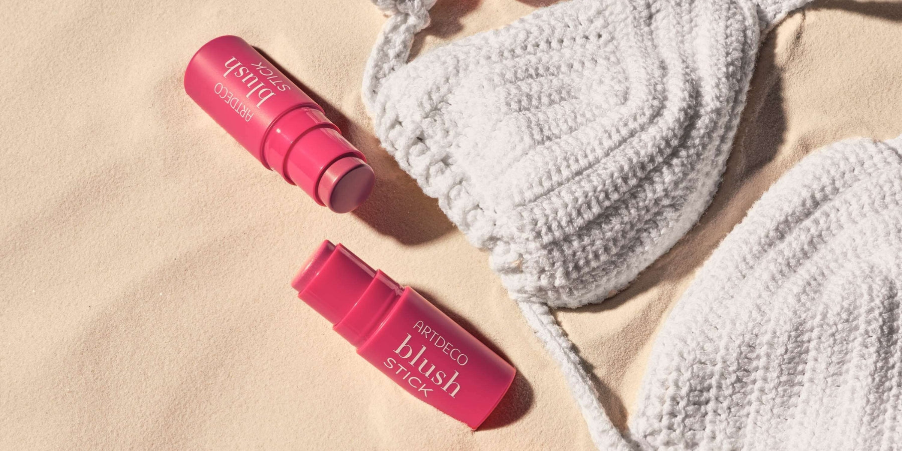 Blush Sticks mit Bikini auf Sand