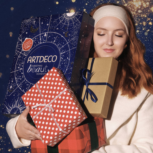 Model hält Geschenke und ARTDECO Adventskalender in den Händen.
