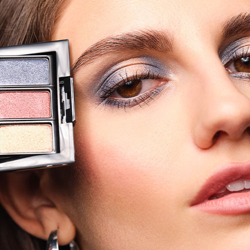 Close-up auf das Gesicht des Models, welche die befüllte Beauty Box mit den neuen Eyeshadows der The Denim Beauty Edit-Kollektion an ihr geschminktes Auge hält