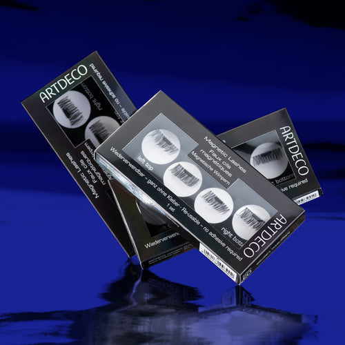 Drei Verpackungen der Artdecp Magnetic Lashes auf blauem Hintergrund.