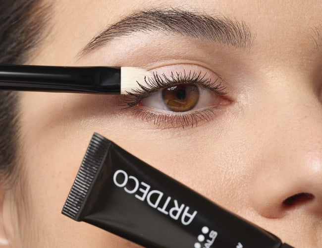 Mit einem Pinsel wird die Mineral Eyeshadow Base Sensitive auf das Augenlid aufgetragen, um die Haltbarkeit des Lidschattens zu verbessern und Leuchtkraft zu intensivieren.