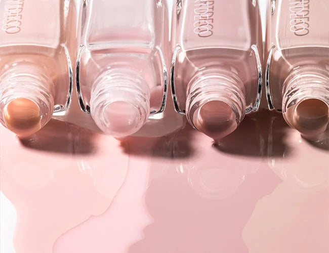 Close-up auf verschiedene Nagellack Flaschen mit ausgelaufenen Farben als Hintergrund