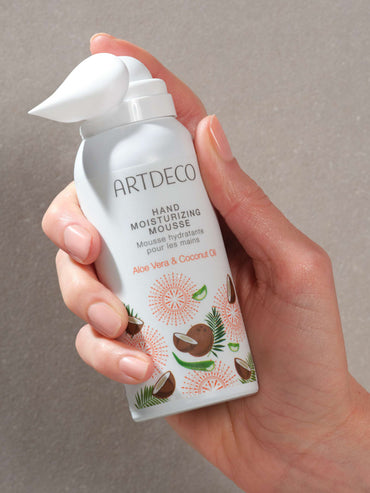 Hand hält limitiertes Hand Moisturizing Mousse und man kann die schaumige Textur sehen