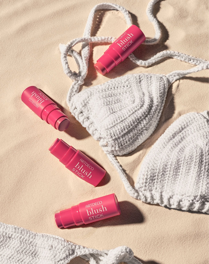 Blush Sticks mit Bikini auf Sand
