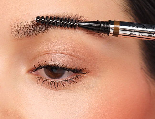 Augenbrauen werden mit der Bürste des 24h Micro Brow Liquid Liners hochgekämmt.
