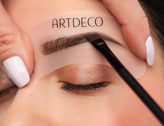 Augenbrauen werden mithilfe einer Schablone und Augenbrauen Puder ausgefüllt.