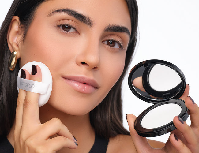 Model trägt mit Puderquaste das ARTDECO No Color Setting Powder für ein langanhaltendes, mattiertes Abend-Make-up.