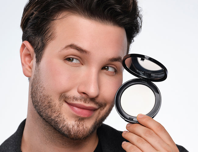 Männliches Model hält das No Color Setting Powder neben sein Gesicht.