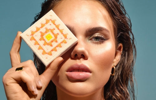 Model hält einen Artdeco Bronzer mit Crochet Design vor dem Gesicht.