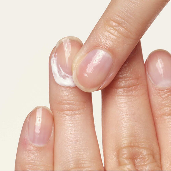 Eine Nagelhautcreme wird auf einem Finger aufgetragen. 
