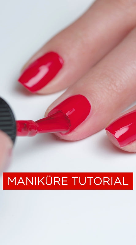 Nägel werden mit roten Nagellack lackiert.