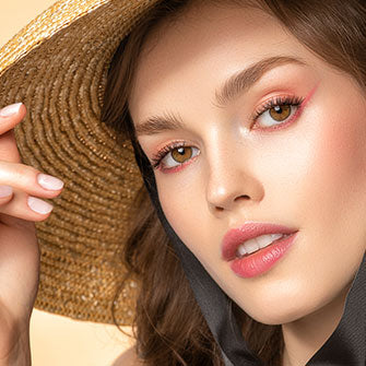 Frau posiert mit sommerlichen Make-up und einem Hut