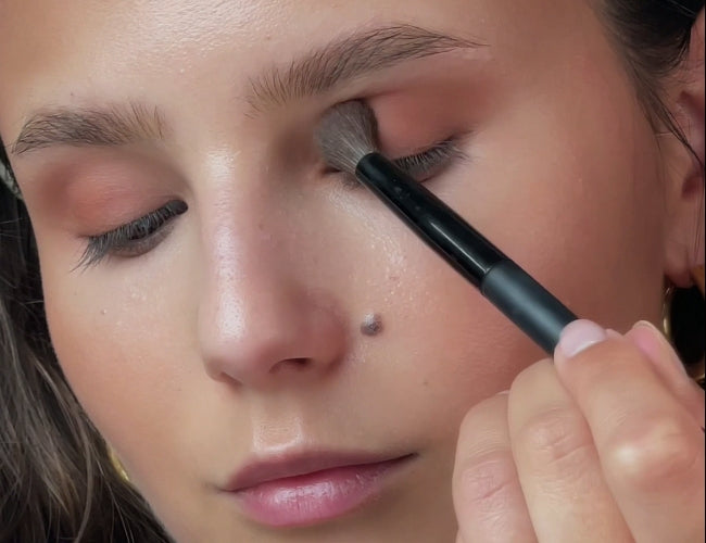 Model trägt Bronzer auf das bewegliche Lid für einen soften Latte-Eyeshadow-Look auf.