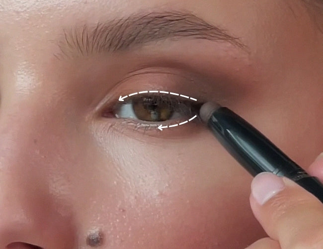 Model verblendet dunklen Cream-Lidschatten am oberen und unteren Wimpernkranz für ein softes, herbstliches Smokey Eye.