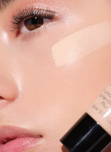 Close-up eines Models, welches sich ein Foundation-Produkt auf die Wange aufträgt.