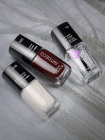 Art Couture Nail Lacquer in den Farben 695, 618 und Gel Look Top Coat platziert auf einem grauen Hintergrund