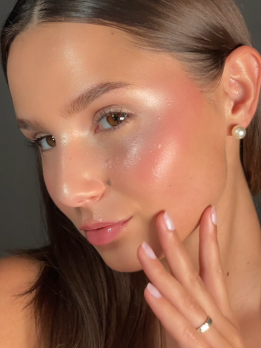Geschminktes Model mit einem glänzenden Make-up schaut seitlich in die Kamera.