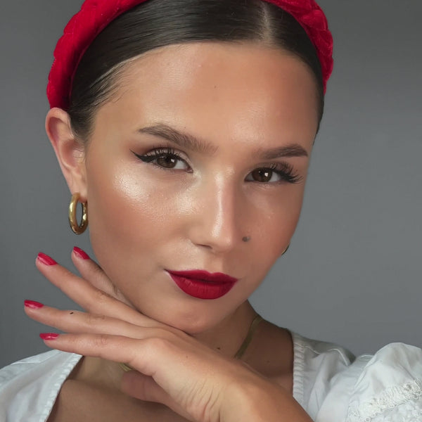Model hält ihre Hand elegant an ihr Gesicht und präsentiert den fertigen Oktoberfest Make-up Look.
